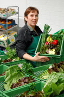 Monika Sannmann von Sannmann Gemüse-Abo mit gepackten Abokisten.